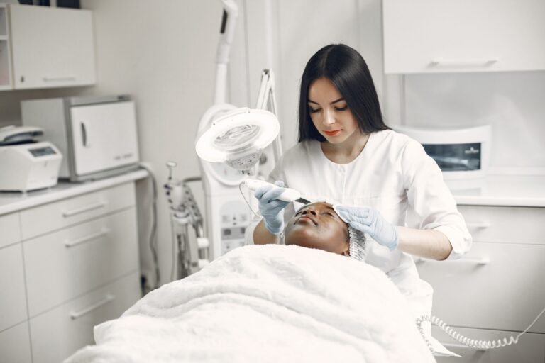 Esteticista aplicando procedimento de limpeza de pele facial