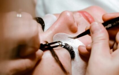 Lash designer aplicando extensão de cílios com pinça, curso Viver de Cílios