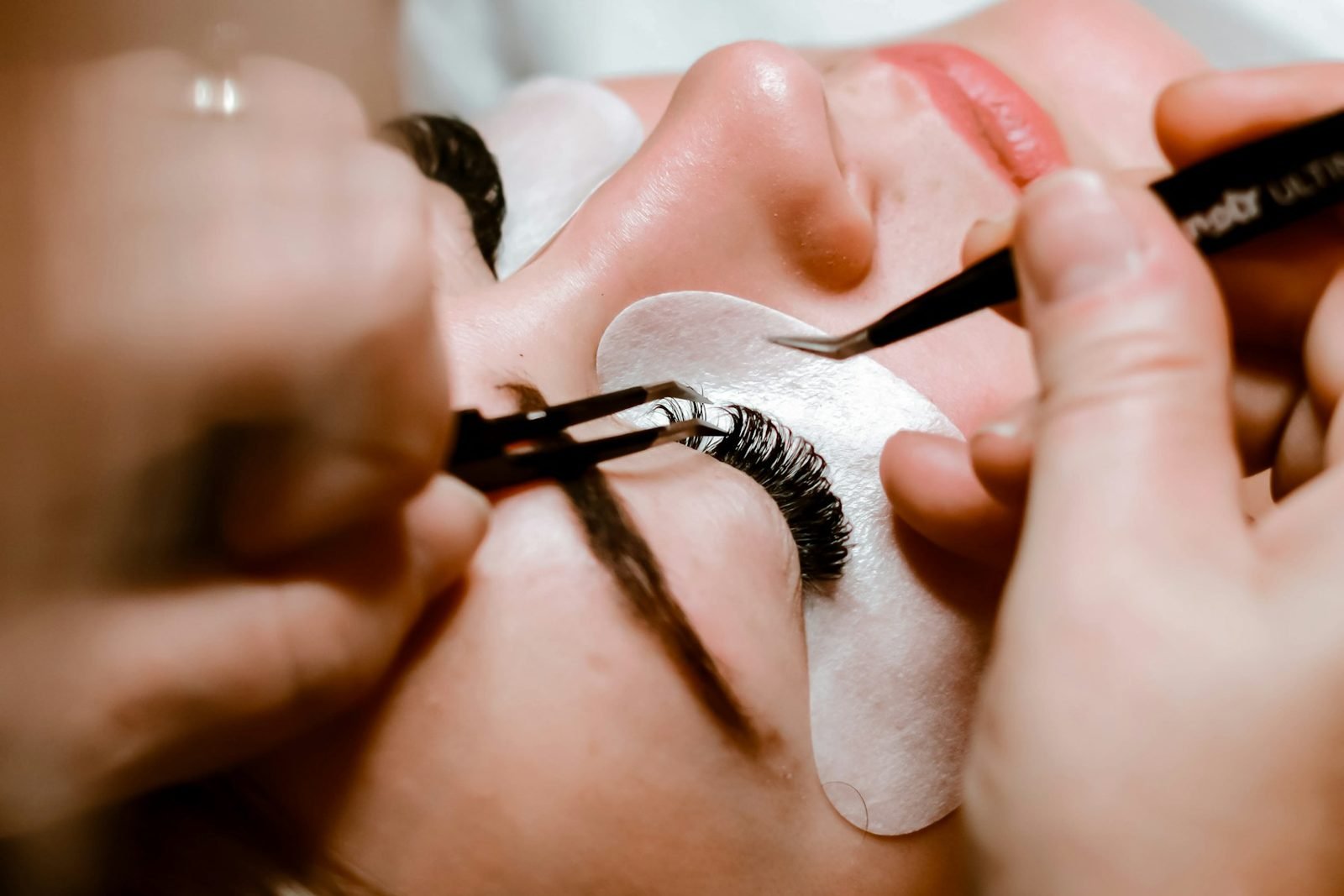 Lash designer aplicando cílios para volume russo com pinça em cliente