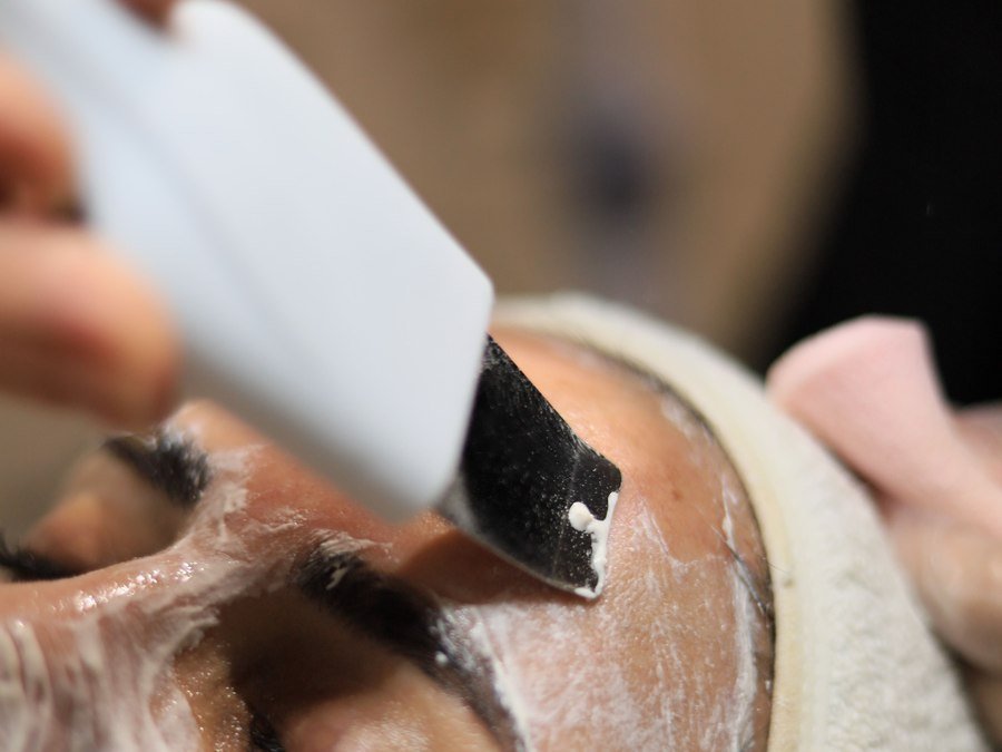 Profissional aplicando espatula durante protocolo de limpeza de pele