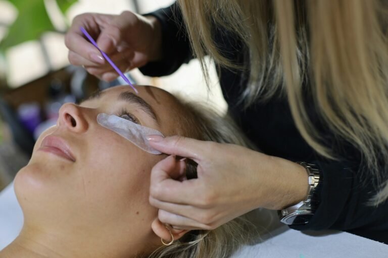 Lash designer aplicando cílios fio a fio com pinça em cliente