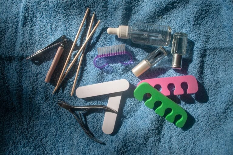 Utensílios de manicure organizados sobre uma toalha, como lixas, alicate e palitos