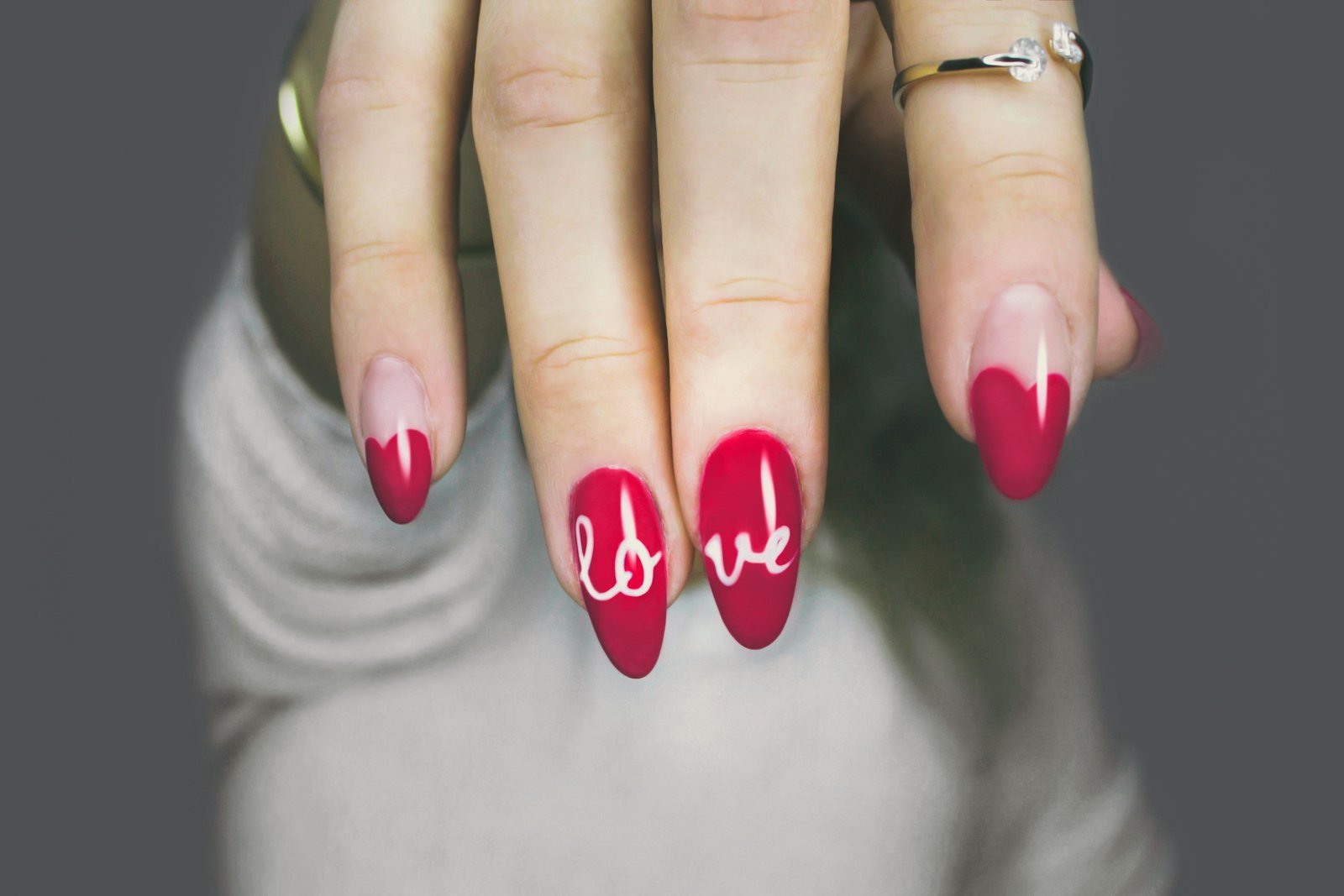 Mãos com unhas em tom rosa e acabamento brilhante, típico de unhas em gel