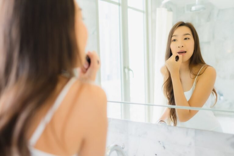 micropigmentação labial antes e depois: mulher conferindo os lábios no espelho com luz natural