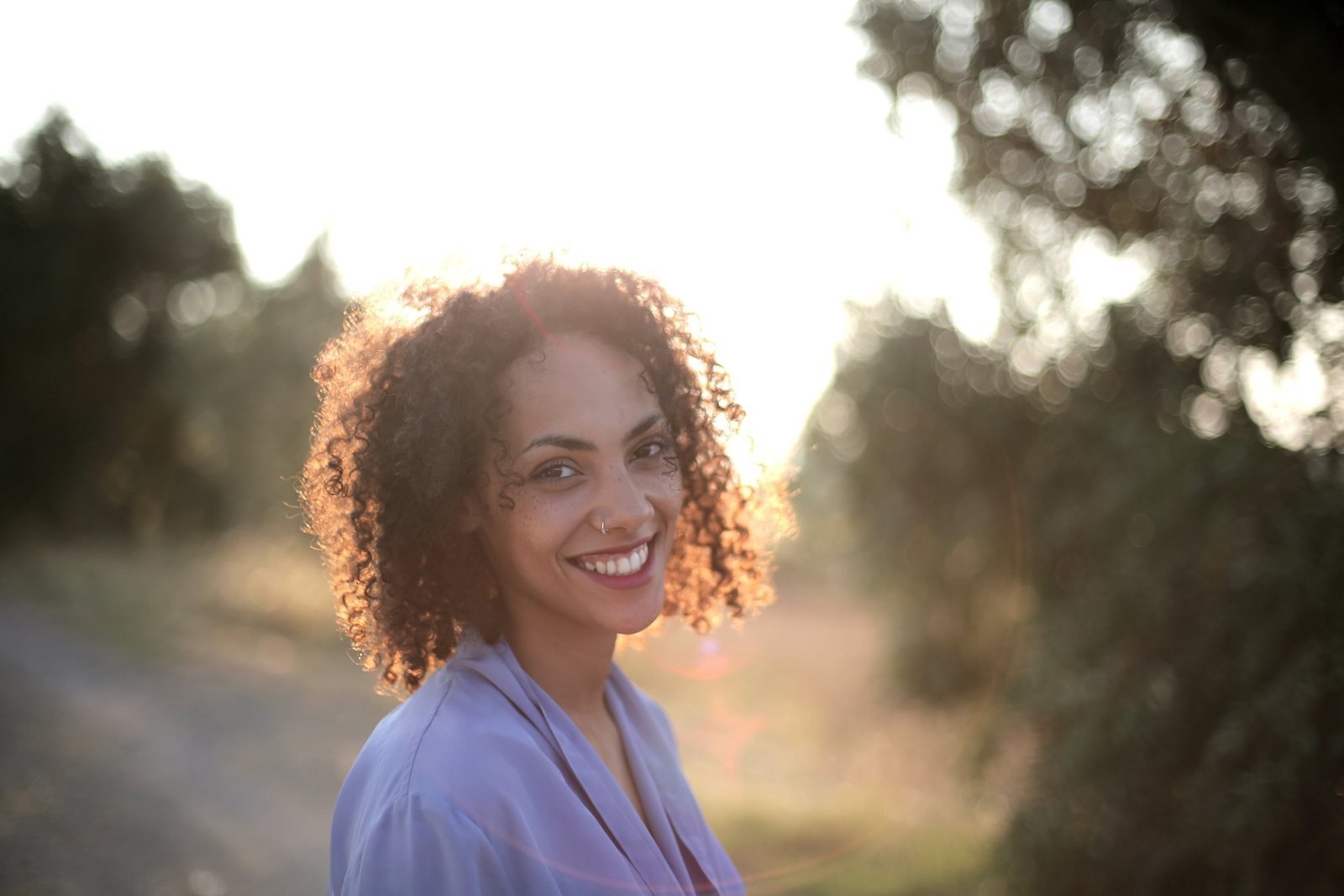micropigmentação labial quanto tempo dura: mulher sorrindo ao ar livre sob luz natural