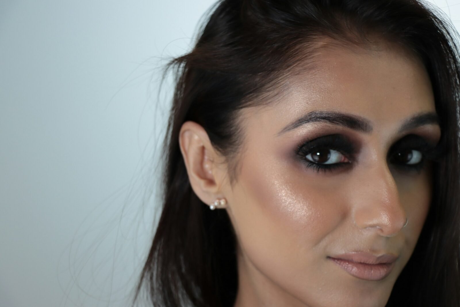 smokey eyes preto: mulher com olho esfumado escuro do rente aos cílios ao côncavo e boca neutra